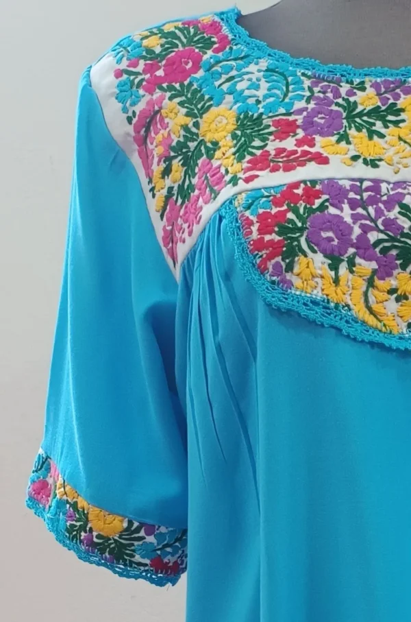 Vestido turquesa bordado colores con holán y bolsas