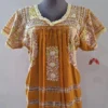 Blusa tela mostaza con deshilado de moños